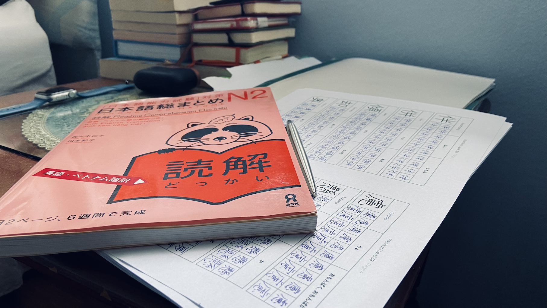 A photo of So-matome Dokkai N2 book and kanji writing worksheets